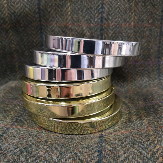 A collection of gold and silver candle lids against a tartan background