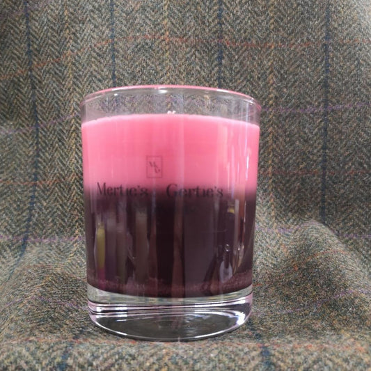 A candle where the top half is pink and the bottom half is plum. It's in a clear glass and can last for up to 40hrs